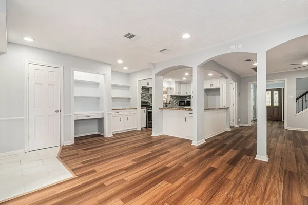 a large white kitchen with white cabinets and stainless steel appliances