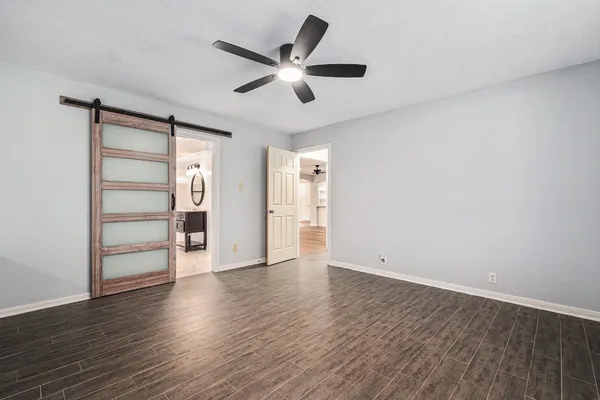a view of an empty room with a window and wooden floor