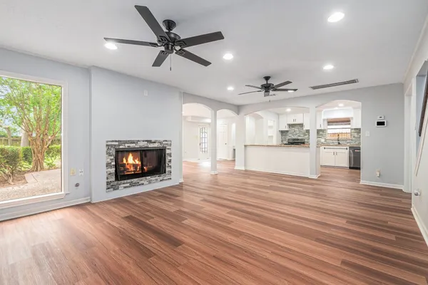 a view of a kitchen with a ceiling fan wooden floor and a kitchen