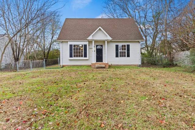 a view of a yard in front of a house with large tree