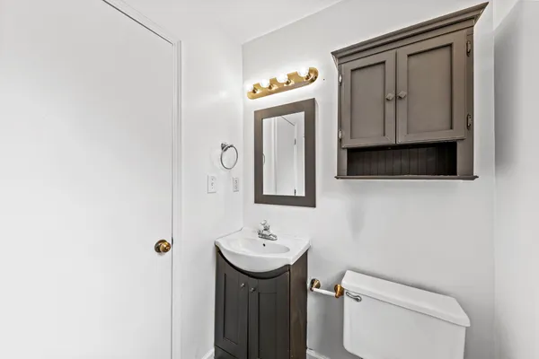 a bathroom with a sink a toilet and mirror