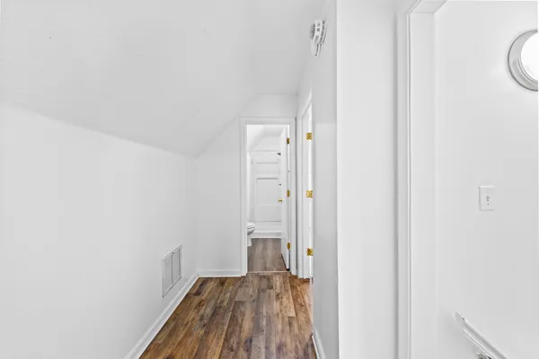 a view of a hallway with wooden floor