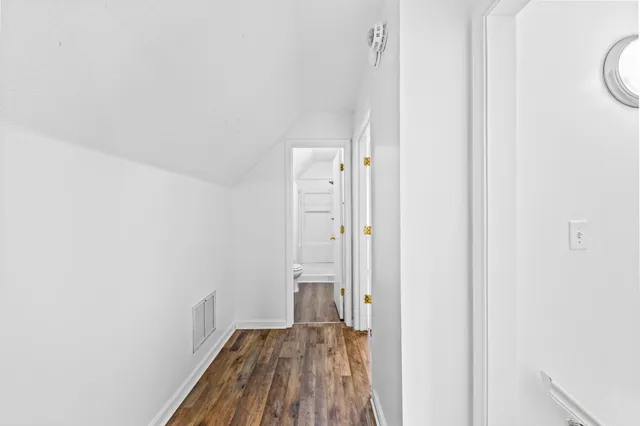 a view of a hallway with wooden floor