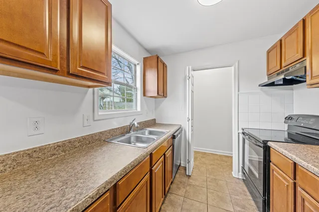 a kitchen with granite countertop a sink stove and cabinets