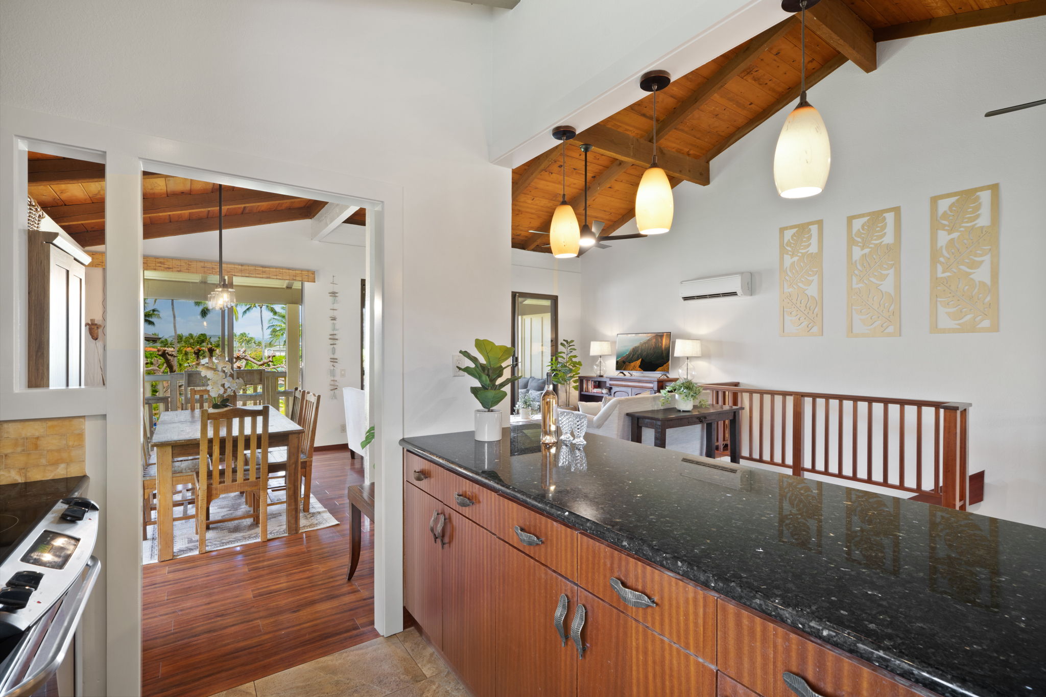 1870 Hoone Road, Unit 600 Koloa, HI 96756 - Photo 11 of 30 a kitchen with granite countertop a stove a sink and a dining table with wooden floor