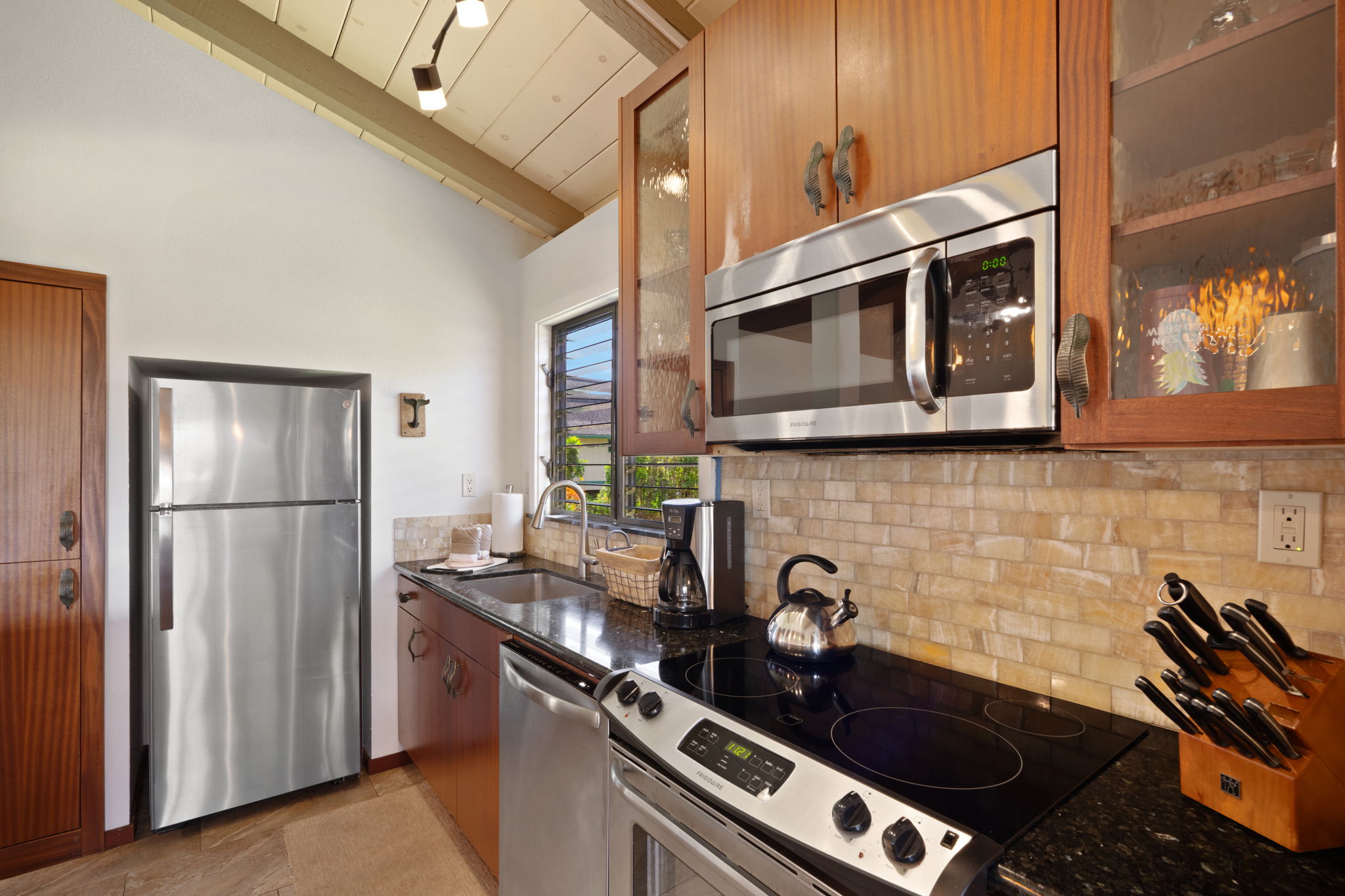 1870 Hoone Road, Unit 600 Koloa, HI 96756 - Photo 17 of 30 a kitchen with stainless steel appliances granite countertop a stove and a refrigerator