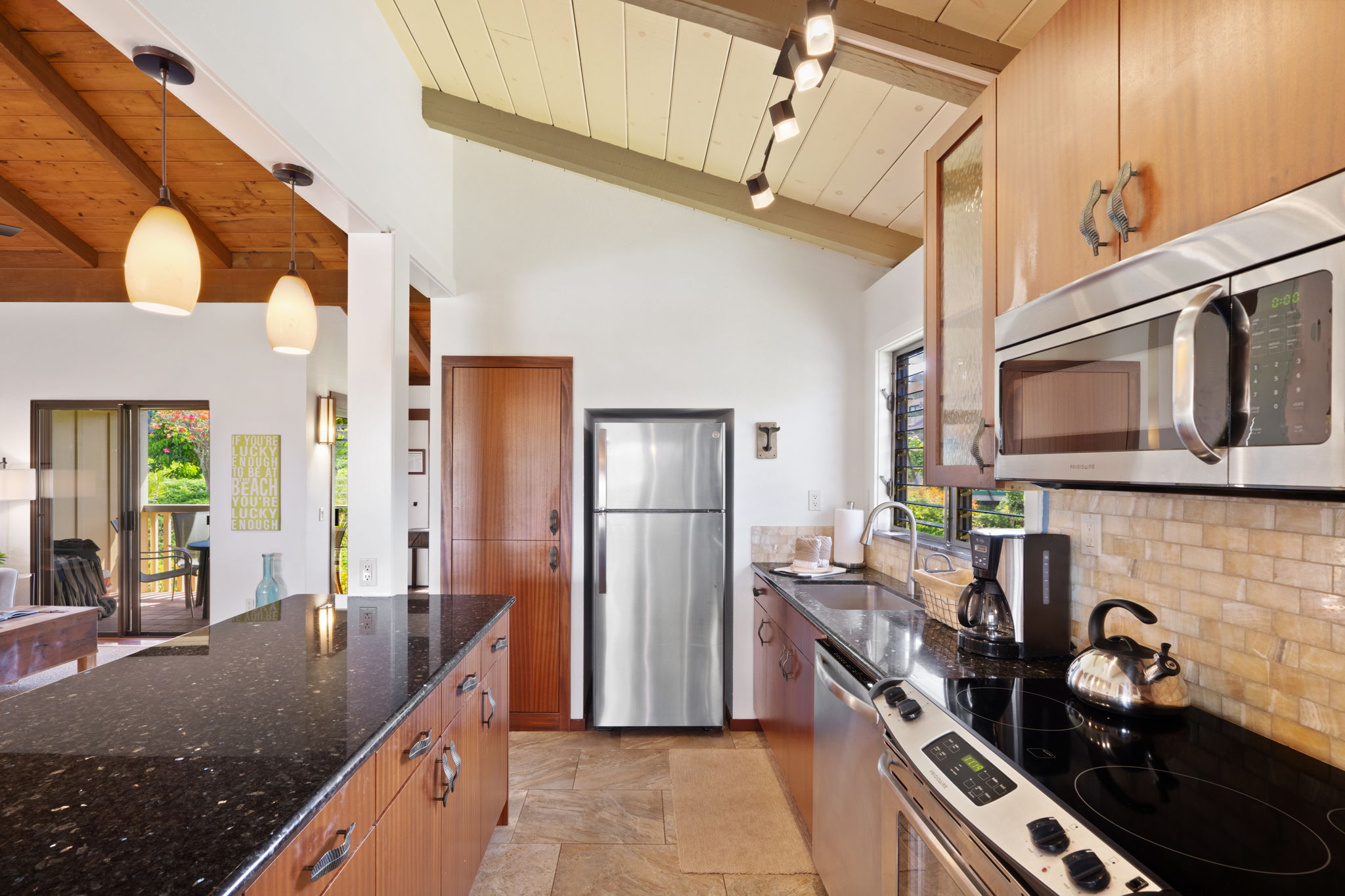 1870 Hoone Road, Unit 600 Koloa, HI 96756 - Photo 18 of 30 a kitchen with stainless steel appliances granite countertop a stove a sink and a microwave