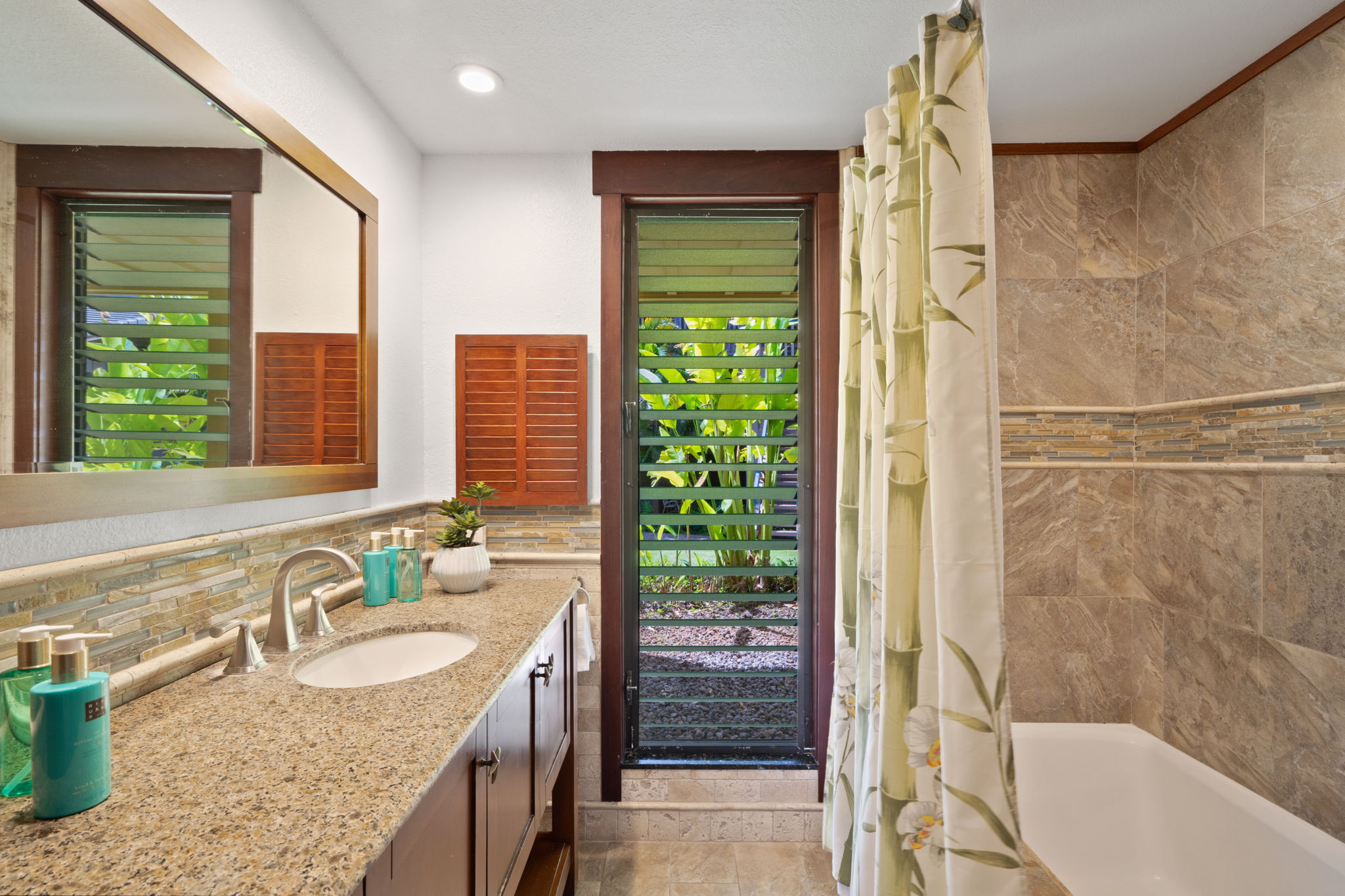 1870 Hoone Road, Unit 600 Koloa, HI 96756 - Photo 26 of 30 a bathroom with a granite countertop sink and a large mirror
