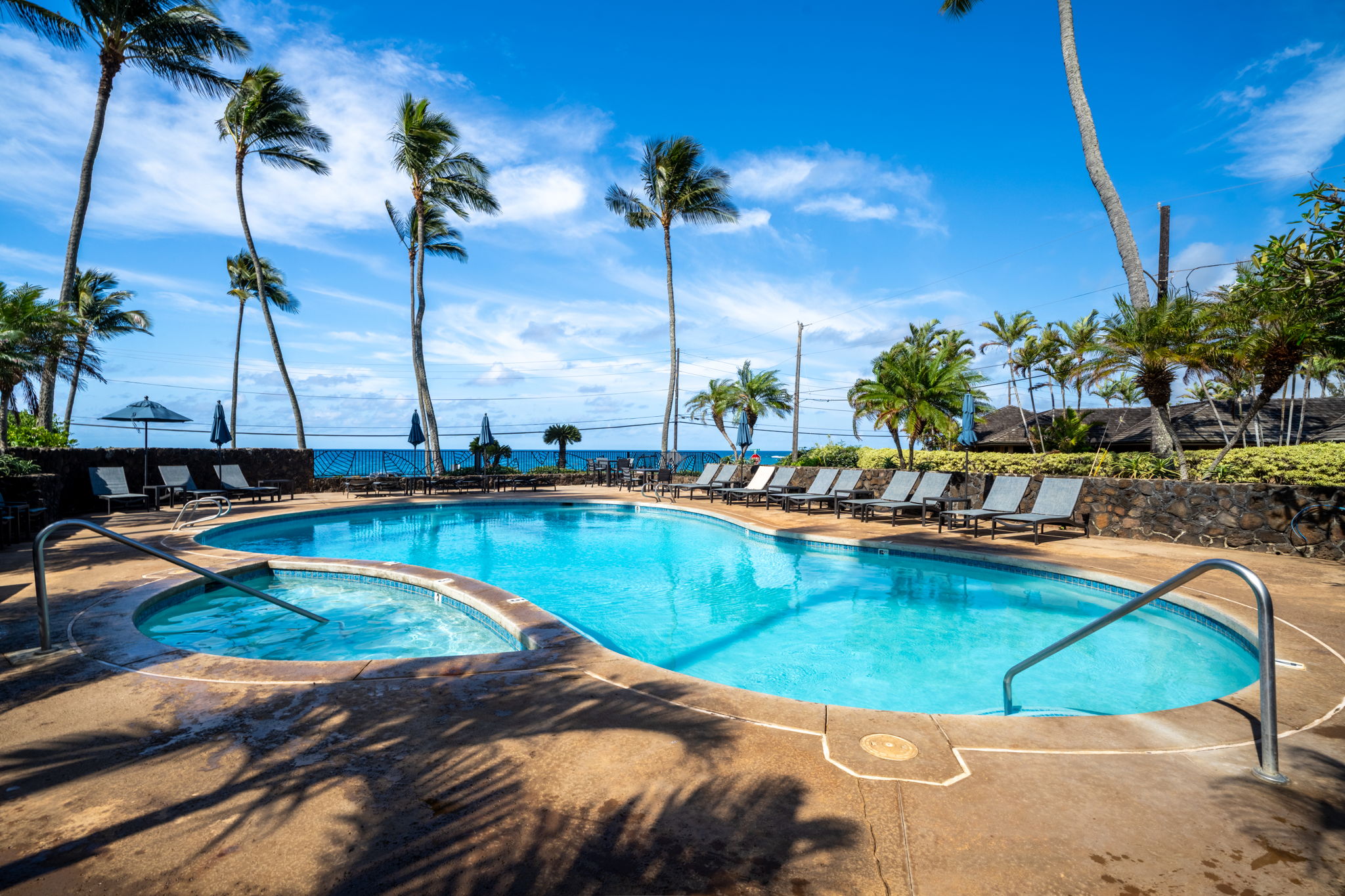1870 Hoone Road, Unit 600 Koloa, HI 96756 - Photo 30 of 30 a view of a swimming pool with a table and chairs