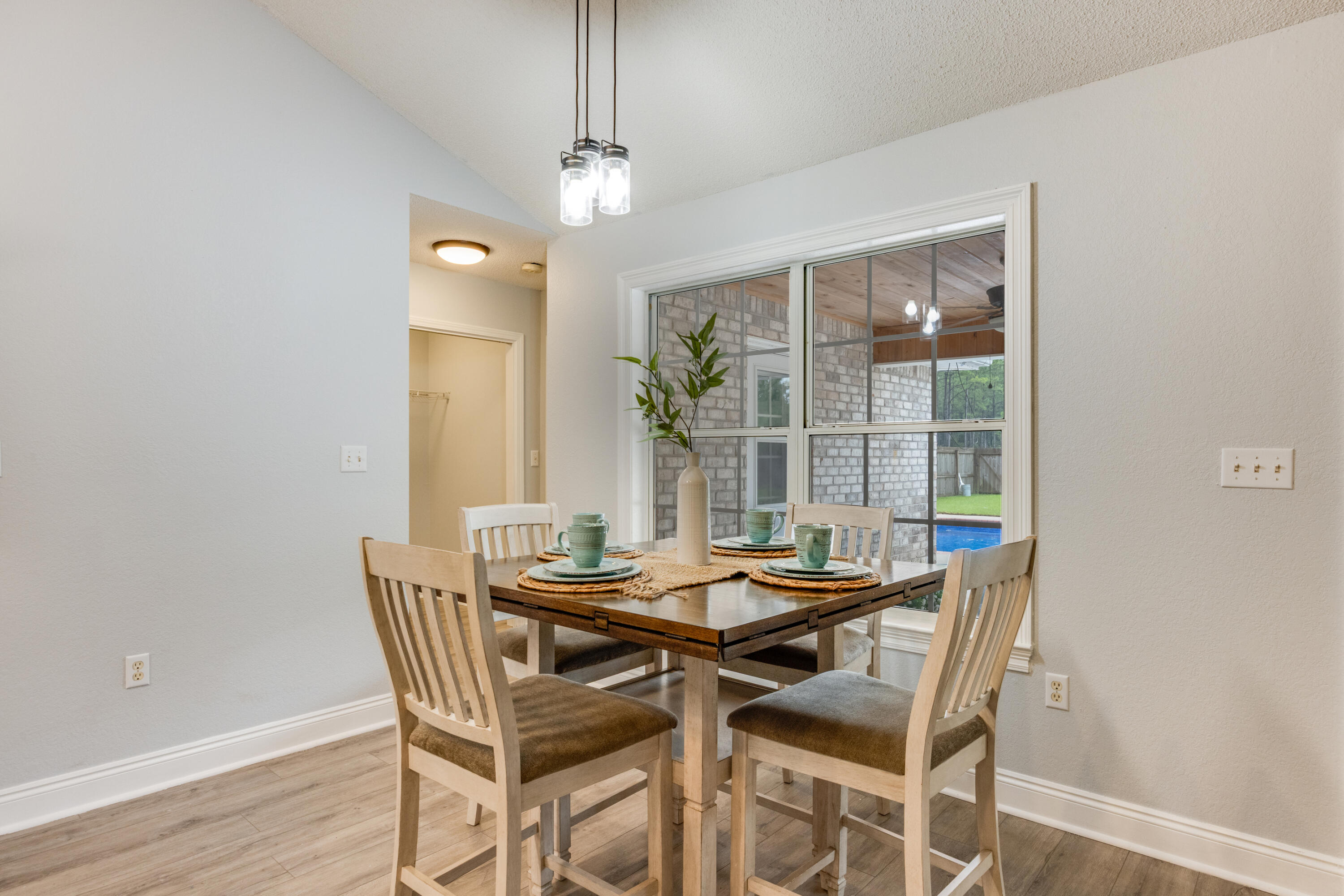 6090 Buckward Road Baker, FL 32531 - Photo 11 of 51 a dining room with furniture a chandelier and wooden floor