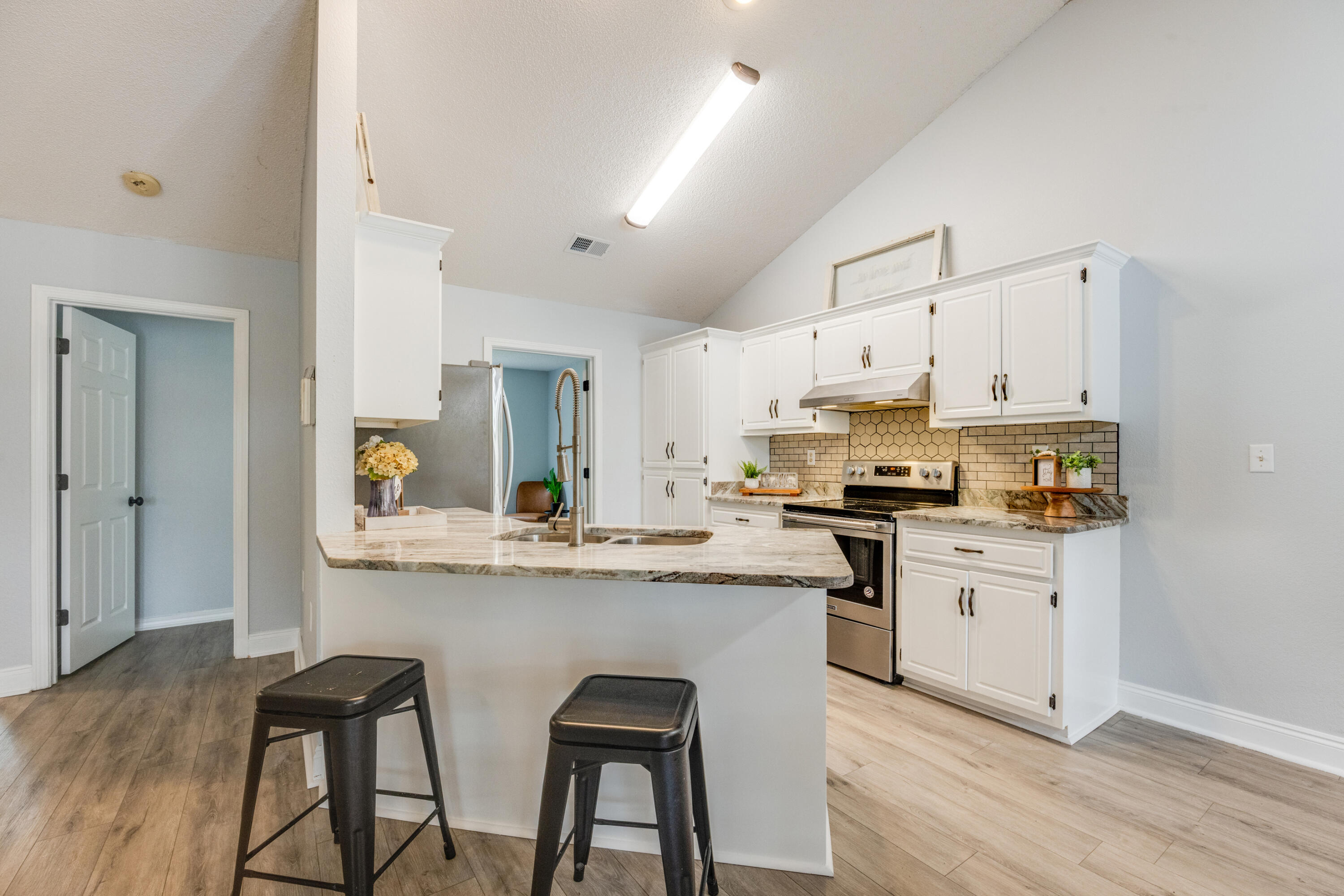 6090 Buckward Road Baker, FL 32531 - Photo 12 of 51 a kitchen with white cabinets and appliances