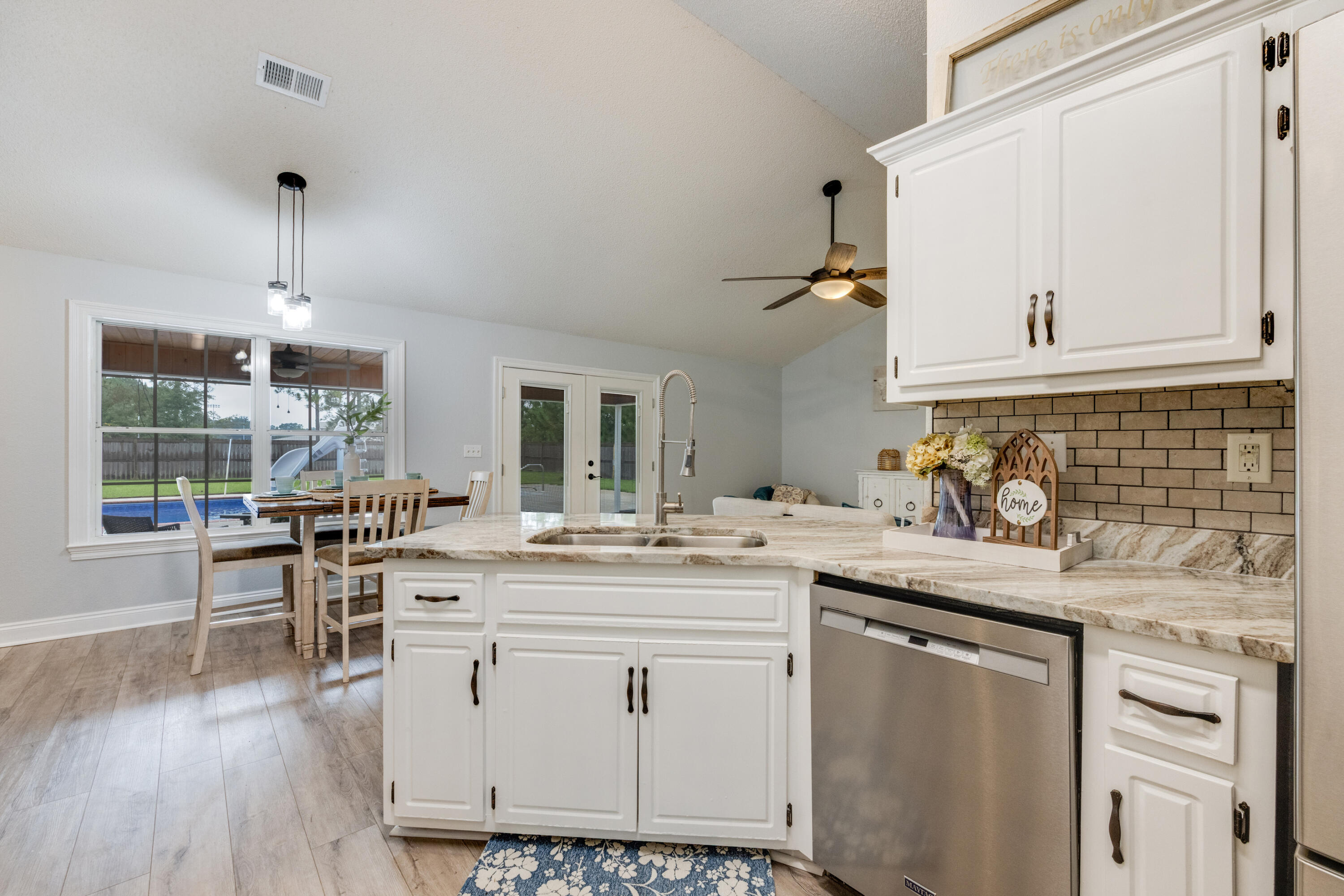 6090 Buckward Road Baker, FL 32531 - Photo 15 of 51 a kitchen with kitchen island granite countertop a sink cabinets and wooden floor