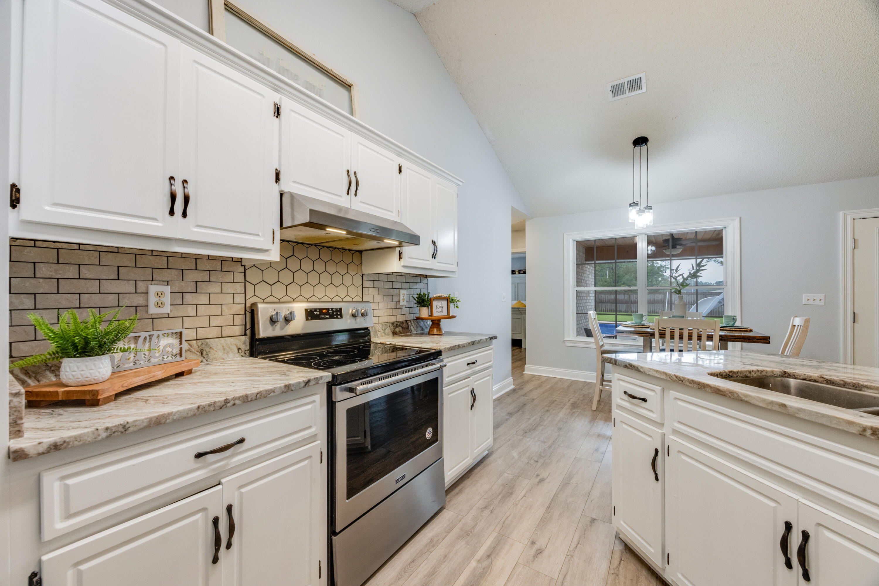 6090 Buckward Road Baker, FL 32531 - Photo 17 of 51 a kitchen with a stove a sink and a wooden floor