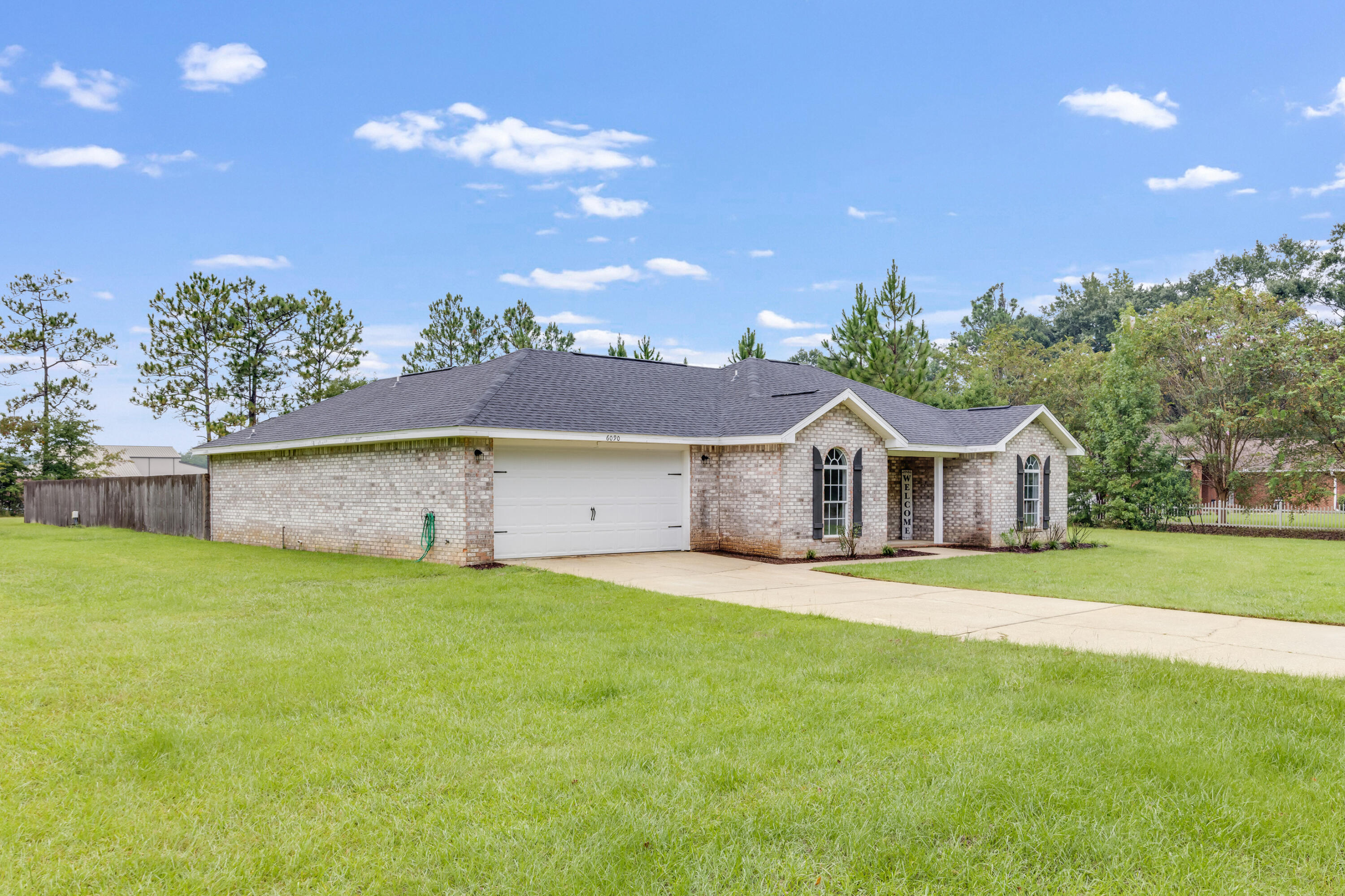 6090 Buckward Road Baker, FL 32531 - Photo 3 of 51 a front view of a house with a garden and yard