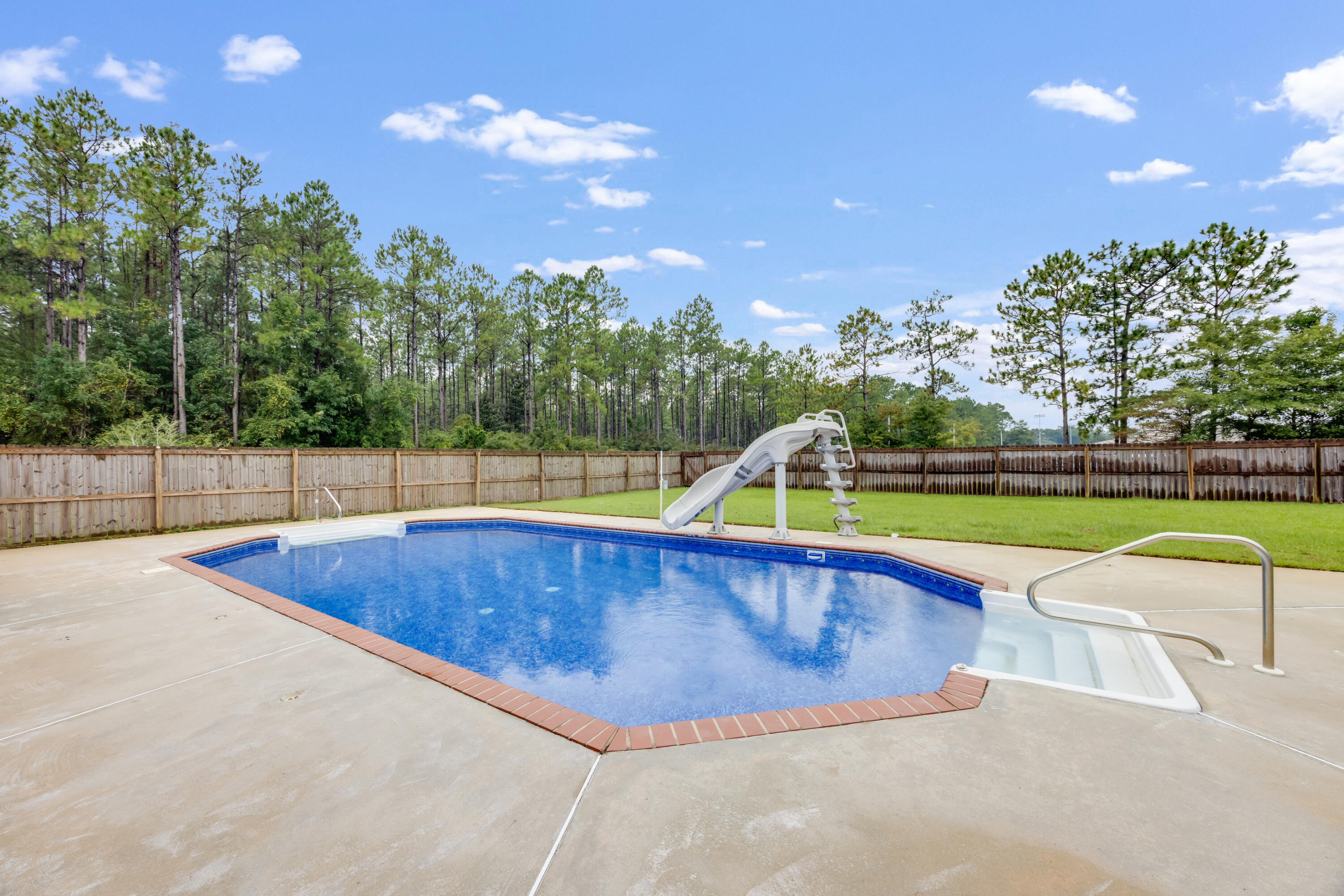 6090 Buckward Road Baker, FL 32531 - Photo 39 of 51 a view of a swimming pool with a yard and palm trees