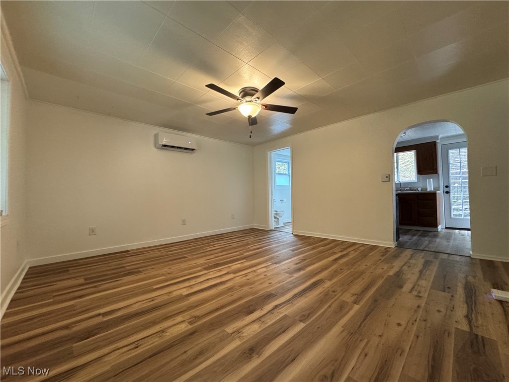 56068 Key Bellaire Road Bellaire, OH 43906 - Photo 2 of 25 Empty room with arched walkways, dark wood-type flooring, and a ceiling fan