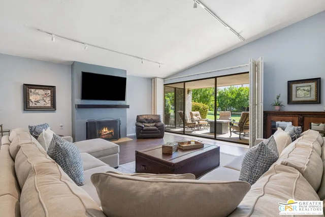 a living room with furniture a fireplace and a flat screen tv