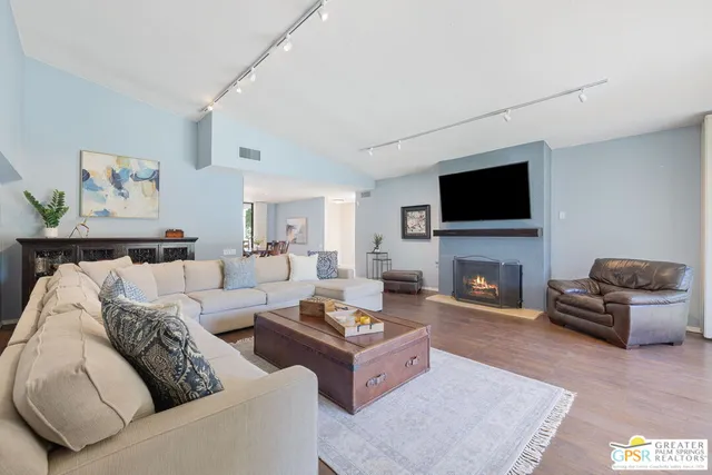 a living room with furniture a fireplace and a flat screen tv