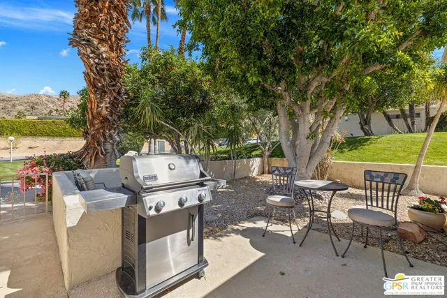 a view of a patio with table and chairs under an umbrella