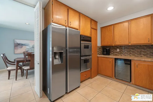 a kitchen with stainless steel appliances granite countertop a refrigerator and a stove top oven