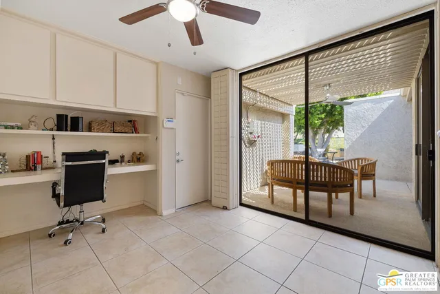 a view of a workspace with furniture and a window