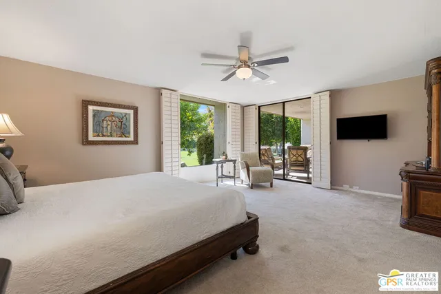 a bedroom with a bed and large windows