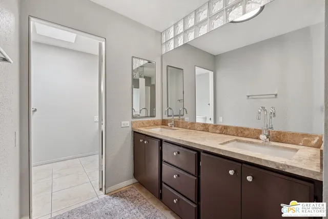 a bathroom with a granite countertop sink a mirror and a shower