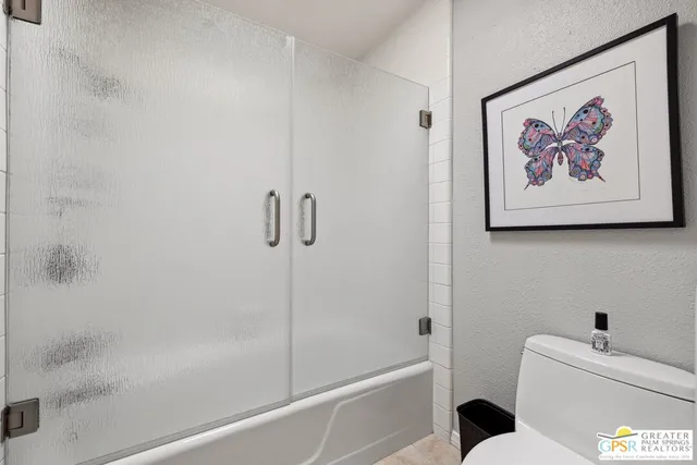 a white toilet sitting next to a bath tub