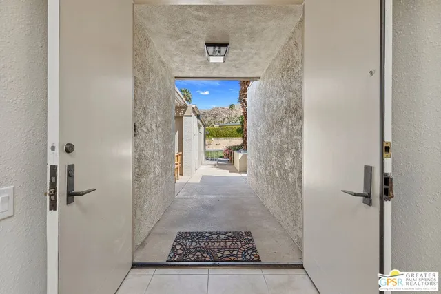 a view of a hallway view with wooden floor and a living room