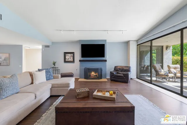 a living room with furniture a flat screen tv and a fireplace