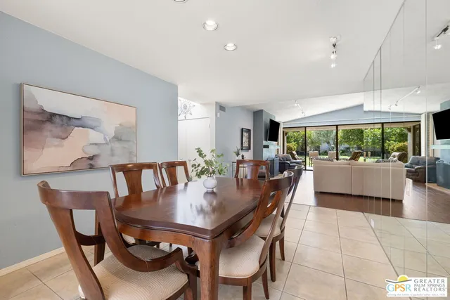 a dining room with furniture and a floor to ceiling window