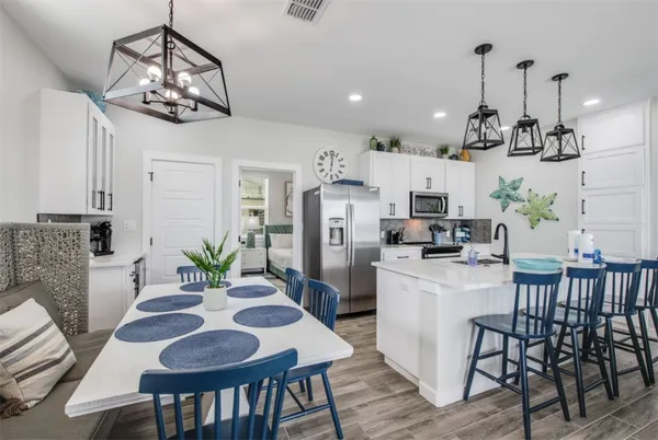 a kitchen with a dining table chairs and white cabinets