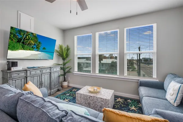 a living room with furniture kitchen view and a chandelier
