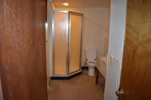 a bathroom with a granite countertop sink and a toilet
