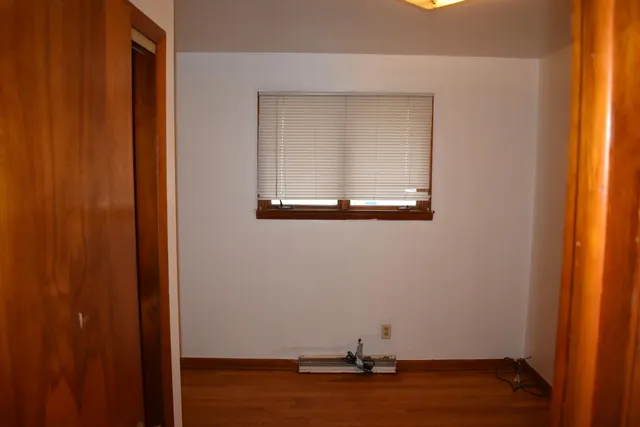 a view of a small space with wooden floor and a window