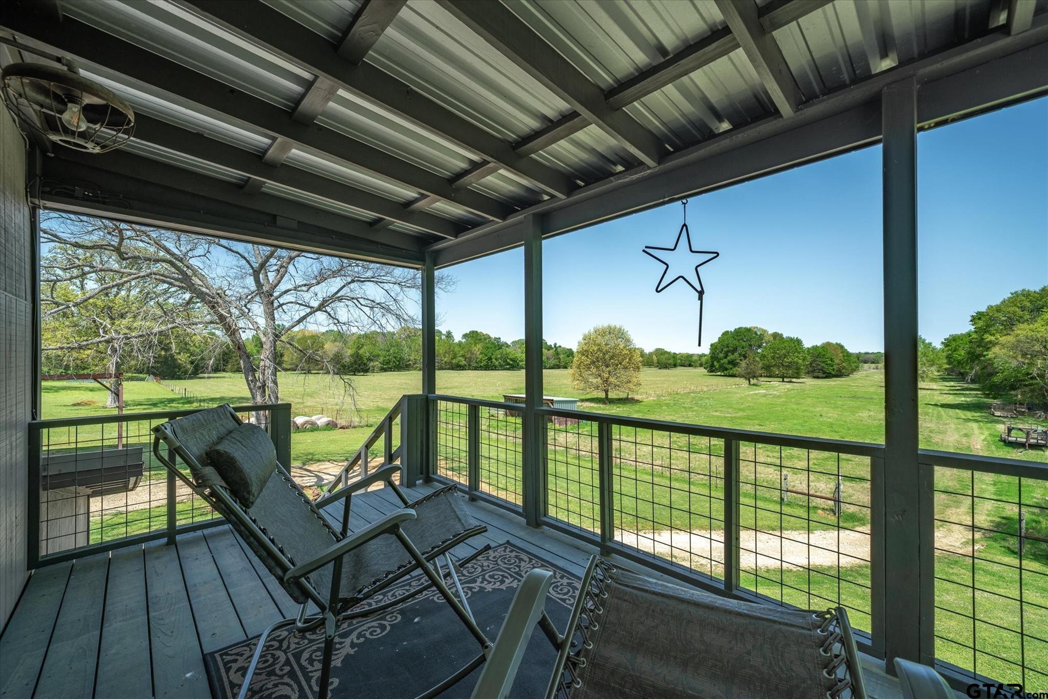 902 County Road 3710 Edgewood, TX 75117 - Photo 18 of 41 a view of a balcony with chairs and wooden floor