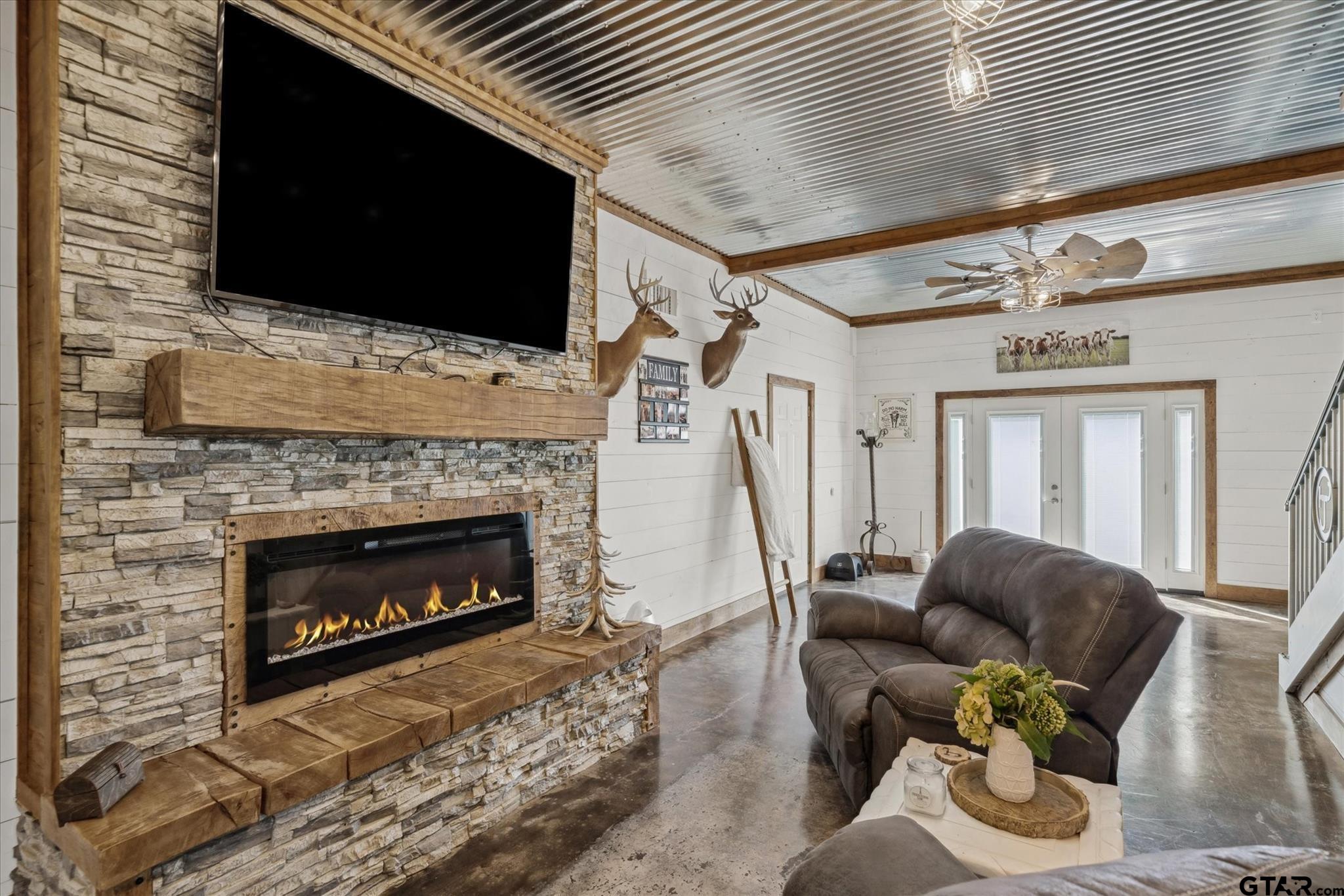 902 County Road 3710 Edgewood, TX 75117 - Photo 3 of 41 a living room with furniture a fireplace and a flat screen tv