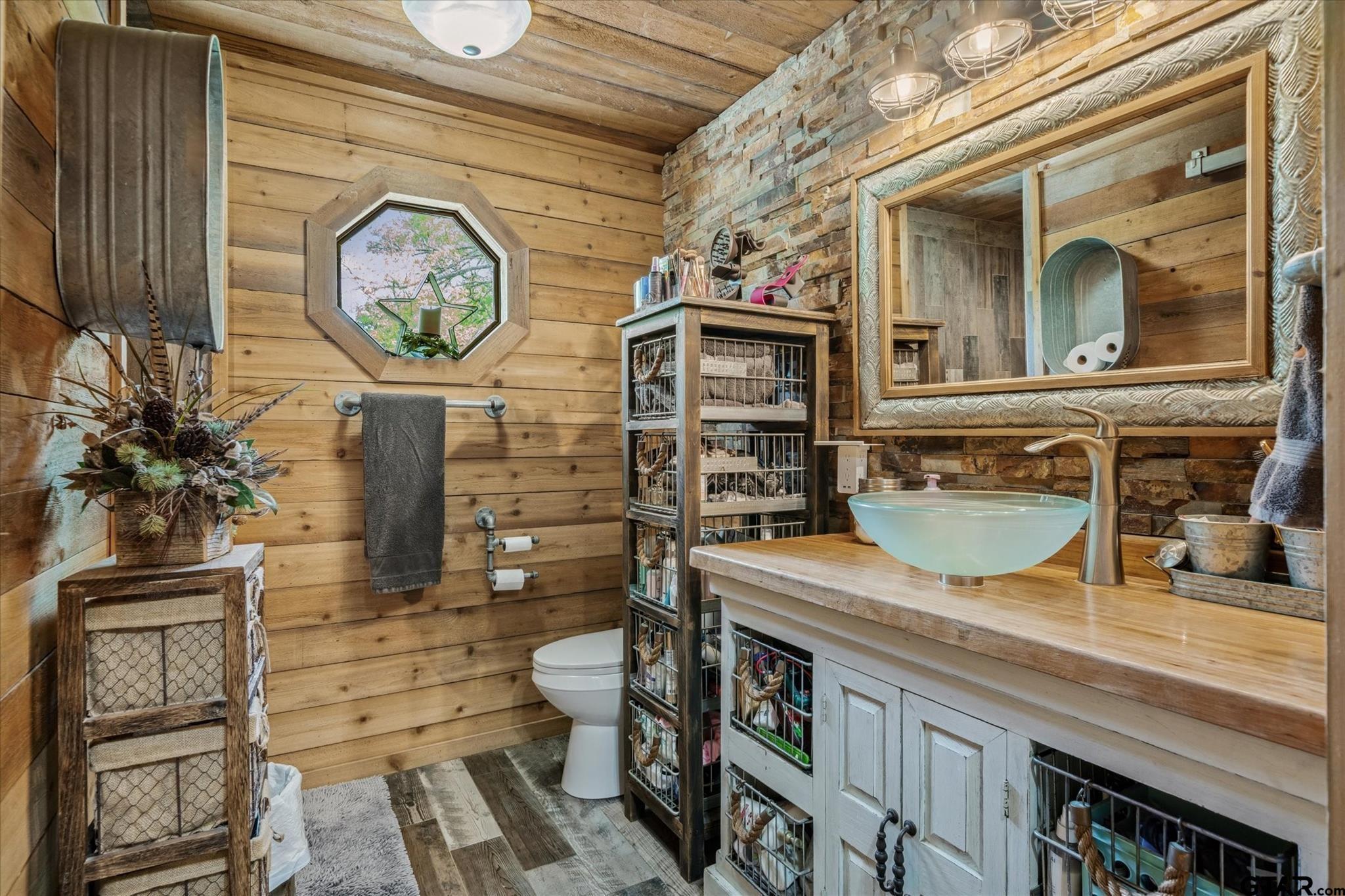 902 County Road 3710 Edgewood, TX 75117 - Photo 34 of 41 a bathroom with a granite countertop toilet sink and mirror