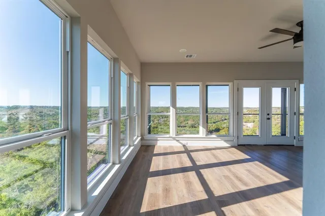 a view of a big room with wooden floor and windows
