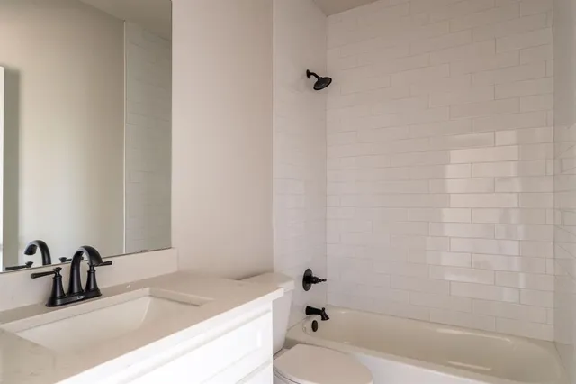 a bathroom with a granite countertop sink and a bathtub
