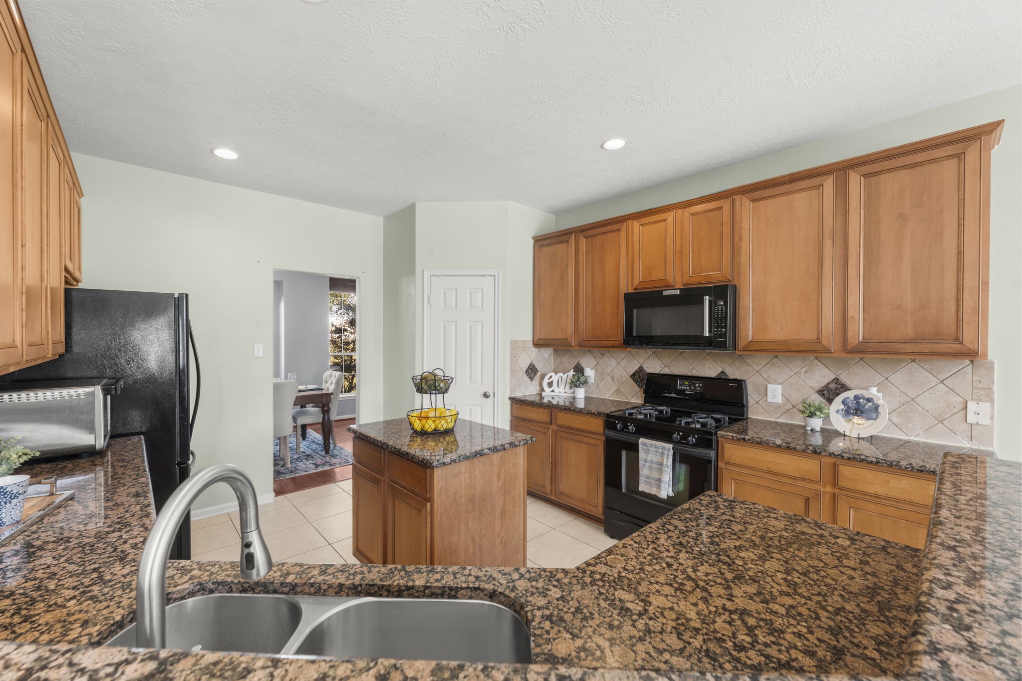 9011 Cedar Run Falls Tomball, TX 77375 - Photo 10 of 30 a kitchen with stainless steel appliances granite countertop a sink stove refrigerator and cabinets