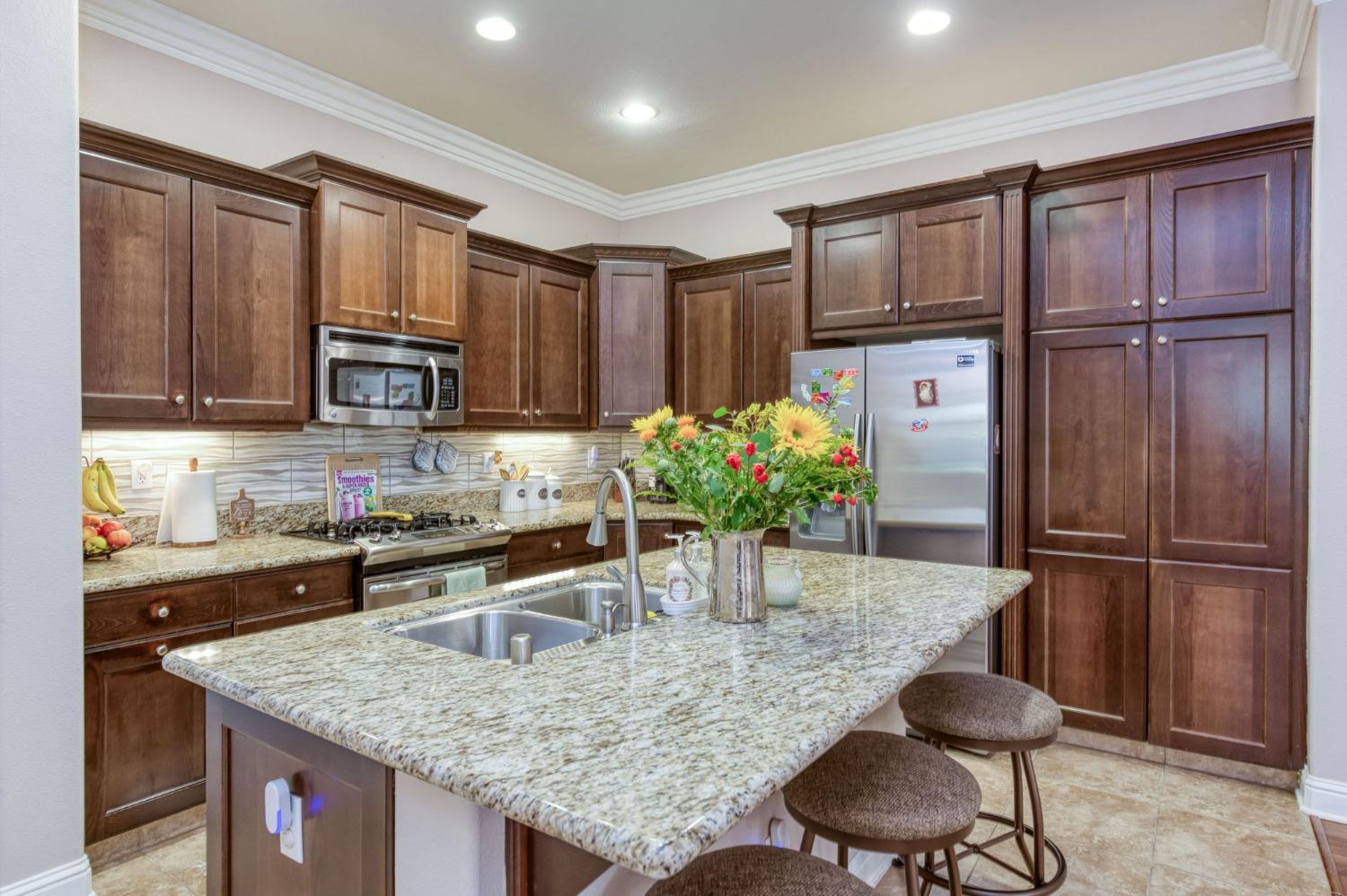 3275 Keats Avenue Clovis, CA 93619 - Photo 17 of 36 a kitchen with granite countertop a refrigerator and a stove top oven