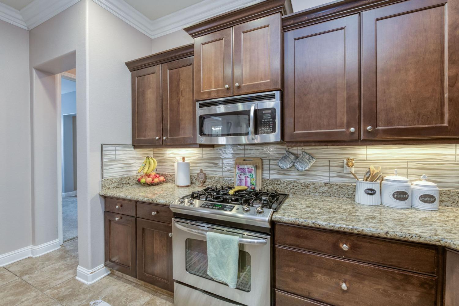 3275 Keats Avenue Clovis, CA 93619 - Photo 19 of 36 a kitchen with granite countertop cabinets stainless steel appliances and wooden cabinets