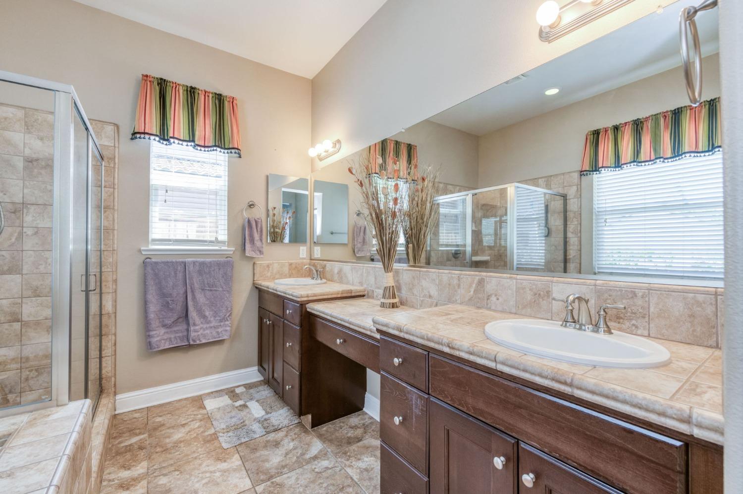 3275 Keats Avenue Clovis, CA 93619 - Photo 26 of 36 a bathroom with a granite countertop sink a mirror and a shower