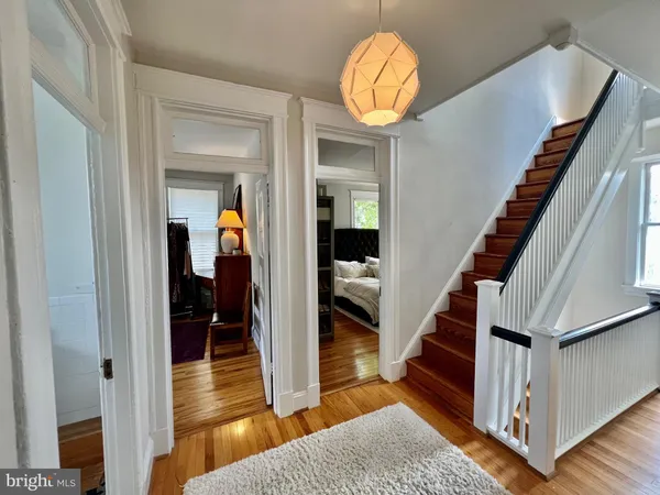 a view of a hallway with wooden floor and staircase
