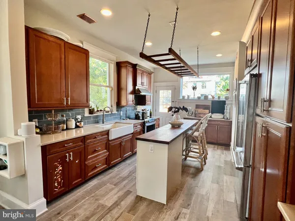a kitchen with stainless steel appliances granite countertop a sink a stove and a refrigerator