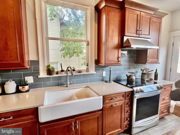 a kitchen with stainless steel appliances a sink a stove and cabinets