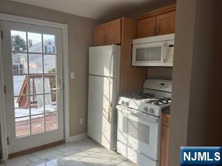 2-38 33rd Street Fair Lawn, NJ 07410 - Photo 6 of 22 a kitchen with a refrigerator a stove top oven and a window