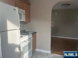 a kitchen with granite countertop a refrigerator and a stove