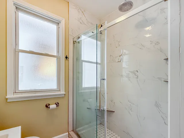 a bathroom with a glass shower door and a sink